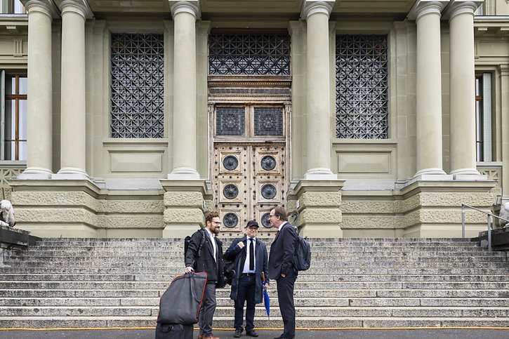 Le journaliste pour le Tages-Anzeiger (au centre) et ses deux avocats à leur arrivée au Tribubal de Montbenon à Lausanne. © Keystone/CYRIL ZINGARO